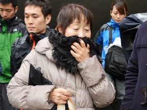 In this undated photo, Chisako Kakehi, centre, answers to a reporter's question in Sakai, western Japan. A Japanese court has sentenced the woman to hang in a serial poisoning murder case targeting elderly men, including her husband.