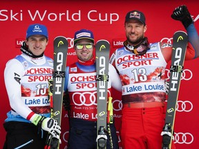 Switzerland's Beat Feuz, centre, Austria's Matthias Mayer, left, and Norway's Aksel Lund Svindal celebrate their first, second and third place finishes respectively, following the men's World Cup downhill ski race at Lake Louise, Alta., Saturday, Nov. 25, 2017. THE CANADIAN PRESS/Jeff McIntosh