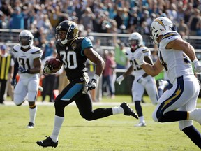 Jacksonville Jaguars running back Corey Grant (30) runs past Los Angeles Chargers safety Adrian Phillips (31) and Derek Watt, right, for a 56-yard touchdown during the first half of an NFL football game, Sunday, Nov. 12, 2017, in Jacksonville, Fla. (AP Photo/Stephen B. Morton)