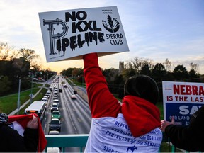 Opponents of the Keystone XL pipeline demonstrate on the Dodge Street pedestrian bridge during rush hour in Omaha, Neb., on Nov. 1, 2017.