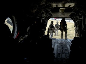 Secret Service Counter Assault Team members load up in a support helicopter as President Donald Trump prepares to depart in Marine One from U.S. Army Garrison Yongsan, Wednesday, Nov. 8, 2017, to travel to the Demilitarized Zone (DMZ) the tense military border between the two Koreas. Marine One turned back because of a bad weather call just minutes away from arriving. Trump is on a five country trip through Asia traveling to Japan, South Korea, China, Vietnam and the Philippines. (AP Photo/Andrew Harnik)