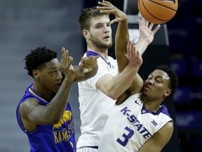 UKMC's Isaiah Ross, left, passes under pressure from Kansas State's Kamau Stokes (3) and Dean Wade during the first half of an NCAA college basketball game, Tuesday, Nov. 14, 2017, in Manhattan, Kan. (AP Photo/Charlie Riedel)