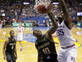 Kansas' Udoka Azubuike (35) gets past Oakland's Isaiah Brock (10) to dunk the ball during the first half of an NCAA college basketball game Friday, Nov. 24, 2017, in Lawrence, Kan. (AP Photo/Charlie Riedel)