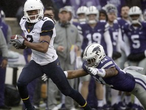 West Virginia wide receiver Ka'Raun White (2) avoids Kansas State defensive back Kendall Adams (21) as he runs 75 yards for a touchdown during the first half of an NCAA college football game, Saturday, Nov. 11, 2017, in Manhattan, Kan. (AP Photo/Charlie Riedel)