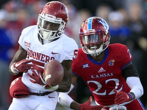 Kansas safety Tyrone Miller Jr. (22) breaks up a pass intended for Oklahoma wide receiver Marquise Brown (5) during the first half of an NCAA college football game in Lawrence, Kan., Saturday, Nov. 18, 2017. (AP Photo/Orlin Wagner)