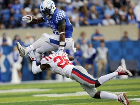 Kentucky running back Benny Snell Jr., top, leaps over Mississippi defensive back C.J. Moore during the first half of an NCAA college football game Saturday, Nov. 4, 2017, in Lexington, Ky. (AP Photo/David Stephenson)