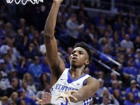Kentucky's Hamidou Diallo, top, shoots while defended by Vermont's Drew Urquhart (25) during the first half of an NCAA college basketball game, Sunday, Nov. 12, 2017, in Lexington, Ky. (AP Photo/James Crisp)