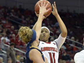 Louisville guard Arica Carter (11) puts up a shot over the defense of Toledo guard Mariella Santucci (3) during the first half of an NCAA college basketball game, Tuesday, Nov. 14, 2017, in Louisville, Ky. (AP Photo/Timothy D. Easley)