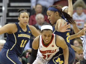 Louisville's Asia Durr (25) works her way around the defense of Michigan's Deja Church (20) during the first half of an NCAA college basketball game, Thursday, Nov. 16, 2017, in Louisville, Ky. (AP Photo/Timothy D. Easley)