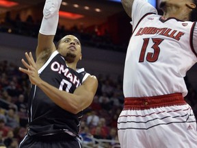 Omaha guard JT Gibson (0) attempts to shoot over the defense of Louisville forward Ray Spalding (13) during the first half of an NCAA college basketball game, Friday, Nov. 17, 2017, in Louisville, Ky. (AP Photo/Timothy D. Easley)