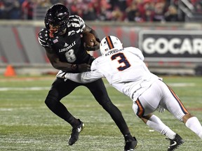 Virginia safety Quin Blanding (3) attempts to wrap up Louisville quarterback Lamar Jackson (8) during the second half of an NCAA college football game, Saturday, Nov. 11, 2017, in Louisville, Ky. Louisville won 38-21. (AP Photo/Timothy D. Easley)