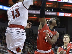 Saint Francis guard Keith Braxton, middle, shoots over Louisville forward Ray Spalding, left, during the first half of an NCAA college basketball game, Friday, Nov. 24, 2017, in Louisville, Ky. (AP Photo/Timothy D. Easley)