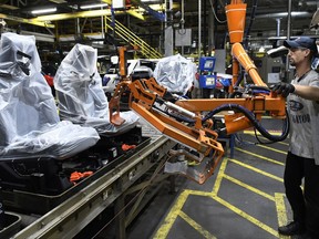 In this Friday, Oct. 27, 2017, photo, workers assemble Ford trucks at the Ford Kentucky Truck Plant in Louisville, Ky.  (AP Photo/Timothy D. Easley)