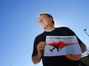 FILE - In this Feb. 6, 2015. file photo, Steve Dreiseszun, a resident of the F.Q. Story historic district in Phoenix, holds a graphic of the increased noise brought on by airplanes flying along new flight paths out of Phoenix Sky Harbor International Airport. The city of Phoenix and the Federation Aviation Administration said Thursday, Nov. 30, 2017, they have come up with a plan aimed at resolving a flap over noisy takeoffs and landings that followed changes in flight procedures at the airport three years ago. (AP Photo/Ross D. Franklin, File)