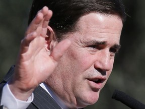 FILE - In this Feb. 11, 2015, file photo, Arizona Gov. Doug Ducey speaks at the "Day at the Capitol" event hosted by the Center for Arizona Policy in Phoenix. Reports that a group of Middle Eastern men had been caught crossing the border illegally from Mexico into Arizona two years ago set off alarms among right-wing blogs and for Ducey. Documents obtained by The Associated Press through a public records request reveal that not only were the men cleared of any ties to terrorism, but they were badly mistreated by two Mexican smugglers with a history of crossing the border illegally. (AP Photo/Matt York, File)