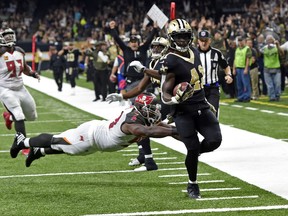 New Orleans Saints running back Alvin Kamara (41) carries for a touchdown past a diving Tampa Bay Buccaneers defensive tackle Clinton McDonald in the first half of an NFL football game in New Orleans, Sunday, Nov. 5, 2017. (AP Photo/Bill Feig)