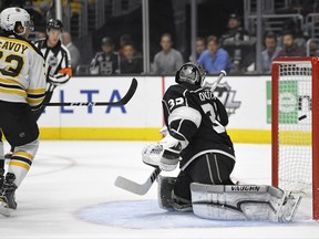 Boston Bruins defenseman Charlie McAvoy, left, scores against Los Angeles Kings goalie Jonathan Quick during the first period of an NHL hockey game, Thursday, Nov. 16, 2017, in Los Angeles. (AP Photo/Mark J. Terrill)