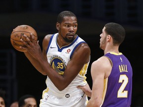 Golden State Warriors forward Kevin Durant, left, is defended by Los Angeles Lakers guard Lonzo Ball during the first half of an NBA basketball game Wednesday, Nov. 29, 2017, in Los Angeles. (AP Photo/Ringo H.W. Chiu)