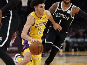 Los Angeles Lakers guard Lonzo Ball, left, dribbles to the basket past Brooklyn Nets guard D'Angelo Russell, right, during the first half of an NBA basketball game, Friday, Nov. 3, 2017, in Los Angeles. (AP Photo/Ryan Kang)