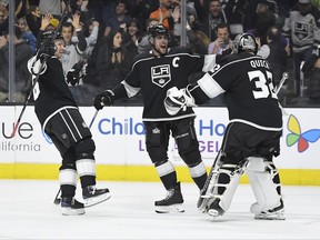 Los Angeles Kings goalie Jonathan Quick, right, celebrates with left wing Jussi Jokinen, left, of Finland, and center Anze Kopitar, of Slovenia, after the Kings defeated the Anaheim Ducks 2-1 in an overtime shootout of an NHL hockey game, Saturday, Nov. 25, 2017, in Los Angeles. (AP Photo/Mark J. Terrill)