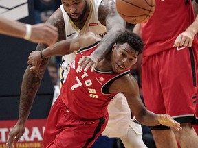 New Orleans Pelicans center DeMarcus Cousins (0) fouls Toronto Raptors guard Kyle Lowry (7) as he reaches for the ball in the first half of an NBA basketball game in New Orleans, Wednesday, Nov. 15, 2017. (AP Photo/Scott Threlkeld)