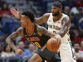Atlanta Hawks forward John Collins (20) drives past New Orleans Pelicans forward DeMarcus Cousins (0) during the first half of an NBA basketball game in New Orleans, Monday, Nov. 13, 2017. (AP Photo/Tyler Kaufman)