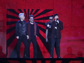 Members of the band U2, Adam Clayton, from left, Bono, Larry Mullen Jr and the Edge collect their Icon award onstage at the MTV European Music Awards 2017 in London, Sunday, Nov. 12th, 2017. (Photo by Joel Ryan/Invision/AP)