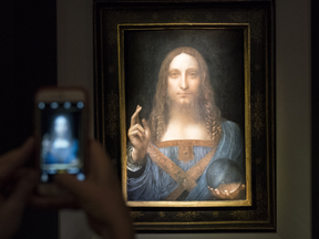 A visitor takes a photo of 'Salvator Mundi' by Leonardo da Vinci at Christie's New York Auction House, Nov. 15, 2017.