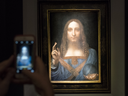 A visitor takes a photo of 'Salvator Mundi' by Leonardo da Vinci at Christie's New York Auction House, Nov. 15, 2017.