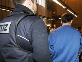 A Romanian truck driver, right, is led into a courtroom in Freiburg, Germany, Wednesday, Nov. 22, 2017. He has confessed to having raped and killed a woman in southwestern Germany at the opening of his trial. The German news agency dpa reported that the 40-year-old said in court that he killed the woman out of "inexplicable aggression," but that he didn't have a sexual motive. (Patrick Seeger/dpa via AP)