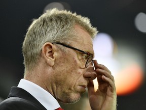 FILE - In this Nov. 2, 2017 file photo Cologne's head coach Peter Stoeger looks skeptical prior a Group H Europa League soccer match between 1. FC Cologne and BATE Borisov in Cologne, Germany. Borussia Dortmund coach Peter Bosz and Cologne counterpart Peter Stoeger both face decisive games with their teams in crisis. Stoeger's position is arguably safer than Bosz's despite the fact that Cologne has made the worst start of any team in 54 years of the league. (AP Photo/Martin Meissner, file )