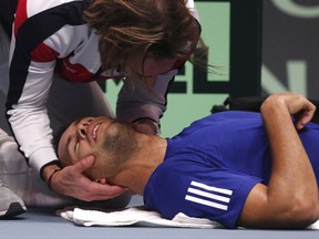 France's Jo-Wilfried Tsonga is being treated after losing the first set against Belgium's David Goffin during their Davis Cup final single match at the Pierre Mauroy stadium in Lille, northern France, Sunday, Nov. 26, 2017. (AP Photo/Michel Spingler)