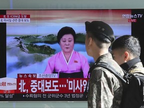 South Korean soldiers walk by a TV screen showing the live broadcast about North Korea's missile launch, at the Seoul Railway Station in Seoul, South Korea, Wednesday, Nov. 29, 2017. After 2 ½ months of relative peace, North Korea launched its most powerful weapon yet early Wednesday, claiming a new type of intercontinental ballistic missile that some observers believe could put Washington and the entire eastern U.S. seaboard within range. The letters on TV read: "North, Important announcement." (AP Photo/Lee Jin-man)