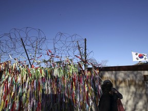 Visitors walk by the wire fence decorated with ribbons carrying messages to wish for the reunification of the two Koreas at the Imjingak Pavilion in Paju, South Korea, Thursday, Nov. 30, 2017. The U.S. ambassador to the United Nations said Wednesday that North Korea's launch of an intercontinental ballistic missile, which some observers believe could reach the Eastern U.S., "brings us closer" to a war the U.S. isn't seeking. (AP Photo/Lee Jin-man)