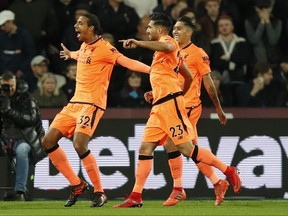 Liverpool's Joel Matip, left, celebrates scoring his sides second goal during the English Premier League soccer match between West Ham and Liverpool at the London Stadium in London, Saturday, Nov. 4, 2017. (AP Photo/Kirsty Wigglesworth)