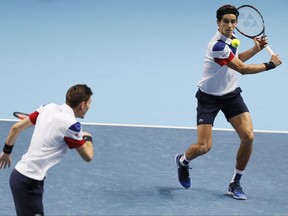 Pierre-Hugues Herbert of France, left, and Nicolas Mahut of France play a return Jean-Julien Rojer of the Netherlands and Horia Tecau of Romania during their doubles tennis match at the ATP World Finals at the O2 Arena in London, Sunday, Nov. 12, 2017. (AP Photo/Kirsty Wigglesworth)