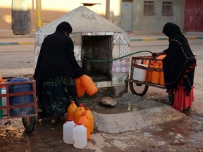 FILE - A Thursday Oct. 19, 2017 file photo of Moroccan women filling up containers with water from a hose, in Zagora, southeastern Morocco. Experts blame poor choices in agriculture, growing populations and climate change for the water shortages in towns like Zagora, which has seen repeated protests for access to clean water in recent weeks. Moroccan state TV channel 2M reports that at least 15 people have died and 5 others have been injured in a stampede Sunday Nov. 19, 2017 as food aid was being distributed in the village of Sidi Boulalam, in the southern province of Essaouira. (AP Photo/Issam Oukhouya, File)