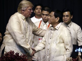 President Donald Trump, left, shakes hands with Philippines President Rodrigo Duterte at an ASEAN Summit dinner at the SMX Convention Center, Sunday, Nov. 12, 2017, in Manila, Philippines. Trump is on a five country trip through Asia traveling to Japan, South Korea, China, Vietnam and the Philippines. (AP Photo/Andrew Harnik)