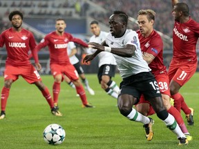 FILE - In this Tuesday, Sept. 26, 2017 file photo, Liverpool's Sadio Mane, front, duels for the ball with Spartak's Andrei Eschenko during the Champions League soccer match between Spartak Moscow and Liverpool in Moscow, Russia. Sadio Mane is returning to Liverpool after being released earlier than expected by Senegal following a recurrence of a hamstring injury. The forward helped Senegal beat South Africa 2-0 on Friday to secure a place in its first World Cup since 2002. (AP Photo/Ivan Sekretarev, File)