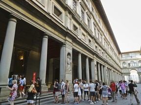 FILE- In this Tuesday, Aug. 1, 2017 file photo, people line up to enter in the Uffizi Gallery in Florence, Italy. The Gallery says lightning struck the museum overnight, setting off alarms that drew both firefighters and anti-terror police. No damage was caused to artwork. (AP Photo/Domenico Stinellis, File)