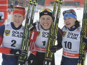FILE - In this Sunday, Jan. 19, 2014 file photo, second placed Russia's Yulia Tchekaleva, left, winner Poland's Justyna Kowalczyk, center, and third placed Russia's Yulia Ivanova pose for photographers after the women's Cross Country skiing 10km Mass Start Classic World Cup event in Szklarska Poreba, Poland. Four more Russian cross-country skiers have been found guilty of doping at the 2014 Sochi Olympics, it was announced on Thursday, Nov. 9, 2017. The Russian Cross-Country Ski Federation says the four have been disqualified by the International Olympic Committee and banned from all future Olympics. The other three skiers found guilty are Alexei Petukhov, Yulia Ivanova and Evgenia Shapovalova. Vylegzhanin won three silver medals in Sochi, but none of the others won a medal.  (AP Photo/Alik Keplicz, file)