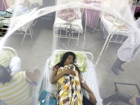 FILE - In this Friday, Feb. 5, 2016 file photo, Nadia Gonzalez, enclosed in a mosquito net, recovers from a bout of dengue fever at a hospital in Luque, Paraguay. Drugmaker Sanofi said Thursday, Nov. 30, 2017, that its dengue vaccine _ the world's first _ could put people at risk of severe disease if they haven't previously been infected, according to new long-term data. (AP Photo/Jorge Saenz, File)