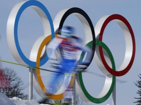 FILE - In this Feb. 23, 2014 file photo taken with slow shutter speed, athletes pass the Olympic rings during the men's 50K cross-country race at the 2014 Winter Olympics in Krasnaya Polyana, Russia. World Anti-Doping Agency investigations into doping haven't encouraged Russian athletes to speak out about abuses, but instead, there is a public hunt for whistleblowers, as Tuesday Nov. 14, 2017, Russia seems to move closer to a ban from the upcoming Winter Olympics.(AP Photo/Dmitry Lovetsky, FILE)