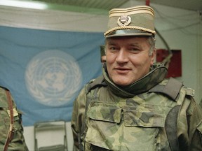 FILE - In this May 17, 1993 file photo, Bosnian Serb commander Gen. Ratko Mladic is pictured near a United Nations flag at Sarajevo Airport. United Nations judges have rejected a defense motion to postpone the verdicts in the long-running genocide and war crimes trial of former Bosnian Serb military chief Ratko Mladic. Defense lawyers had argued that the judgment, scheduled to be delivered by an international criminal tribunal on Nov. 22, 2017 should be delayed so Mladic could be examined by Serbian doctors. (AP Photo/Jerome Delay, File)