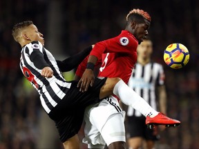Newcastle United's Dwight Gayle, left, and Manchester United's Paul Pogba battle for the ball during their English Premier League soccer match at Old Trafford, Manchester, England, Saturday, Nov. 18, 2017. (Martin Rickett/PA via AP)