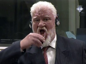 In this photo provided by the ICTY on Wednesday, Nov. 29, 2017, Slobodan Praljak brings a bottle of poison to his lips during a Yugoslav War Crimes Tribunal in The Hague, Netherlands.