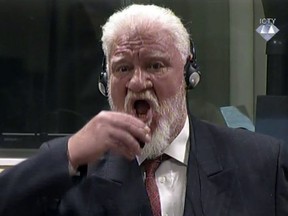 In this photo provided by the ICTY on Wednesday, Nov. 29, 2017, Slobodan Praljak brings a bottle to his lips, during a Yugoslav War Crimes Tribunal in The Hague, Netherlands. Praljak yelled, "I am not a war criminal!" and appeared to drink from a small bottle, seconds after judges reconfirmed his 20-year prison sentence for involvement in a campaign to drive Muslims out of a would-be Bosnian Croat ministate in Bosnia in the early 1990s. (ICTY via AP)