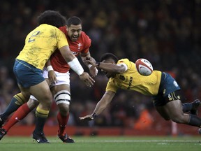 Wales' Taulupe Faletau is tackled by Australia's Tatafu Polota-Nau, left, and Tevita Kuridrani during a rugby union international match at the Principality Stadium, Cardiff, Saturday Nov. 11, 2017. (David Davies/PA via AP)