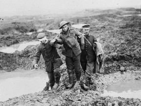 A Canadian and two German prisoners of war struggle through the mud of Passchendaele.