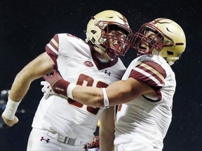 Boston College wide receiver Chris Garrison, right, celebrates his touchdown with tight end Tommy Sweeney during the second quarter of an NCAA college football game against Connecticut at Fenway Park in Boston, Saturday, Nov. 18, 2017. (AP Photo/Michael Dwyer)